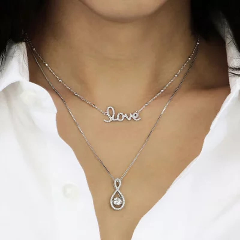 Dancing Lab Created White Sapphire and 0.12 CT. T.W. Diamond Infinity Pendant in Sterling Silver